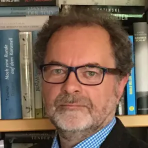 Mann mit Brille und graumeliertem Bart