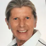 Frau mit grau melierten Haaren und weißer Bluse