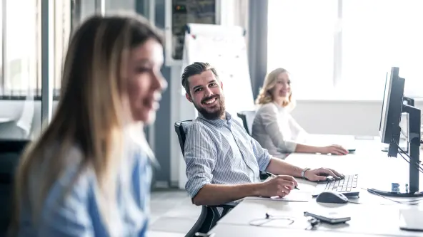 3 Personen in einem Büro lachen