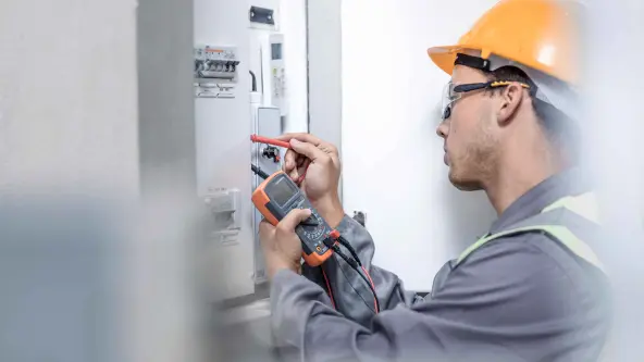Junger Elektriker arbeitet an einem Sicherungskasten