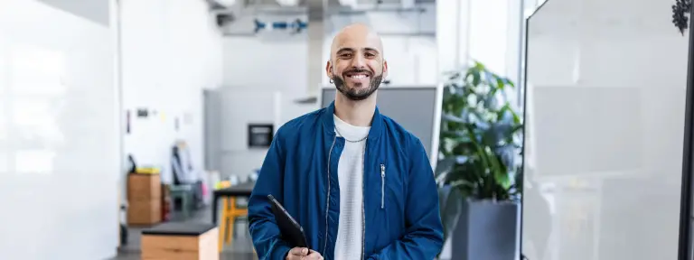 Ein junger Mann steht mitten in einem Bürogebäude