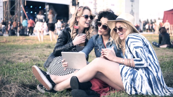 3 junge Frauen machen lachend ein Selfie bei einem Festival