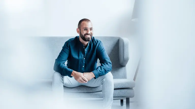 Lächelnder Mann sitz auf dem Sofa