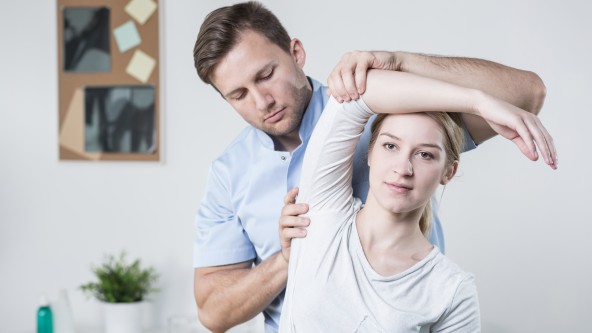 Junge Frau in Praxis zur Behandlung von Rückenschmerzen