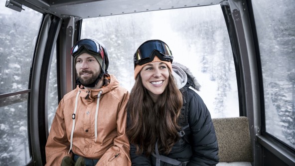 Junges Paar beim Skifahren in Gondel