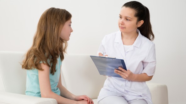 Ärztin mit Mädchen in Praxis