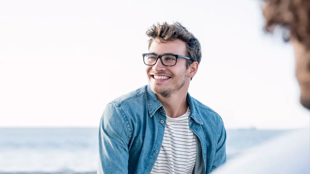 Junger Mann mit Brille lacht