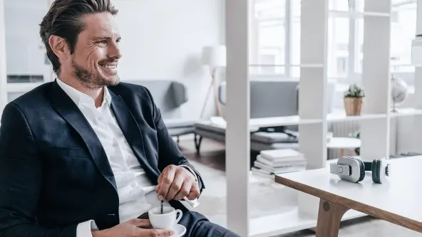 Mann im Anzug trinkt einen Espresso