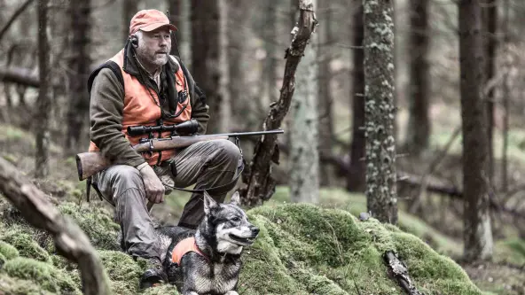 Jäger mit Hund im Wald