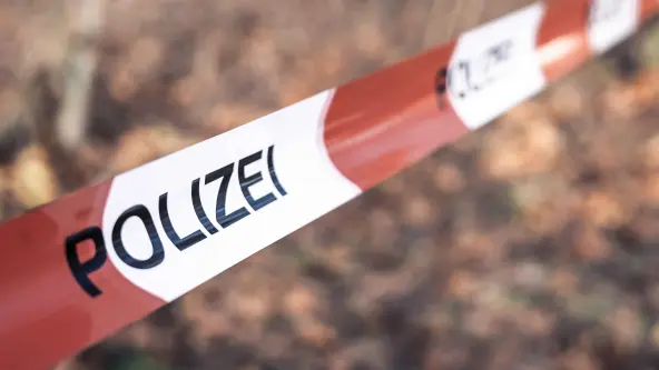 Rot weißes Absperrband in einem Wald auf dem Polizei steht