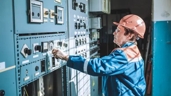 Ältere Dame arbeitet an einer industriellen Maschine
