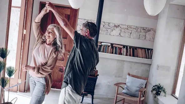Mann und Frau tanzen durch Wohnung