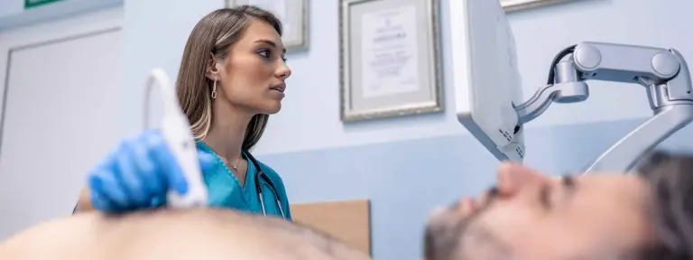 Ärztin untersucht Herz eines Patienten mit Ultraschall