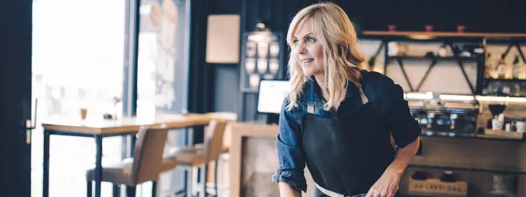 Blonde Frau räumt einen Tisch in einem Restaurant ab