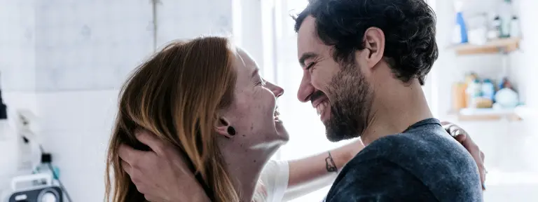 Mann und Frau umarmen und lachen sich innig an