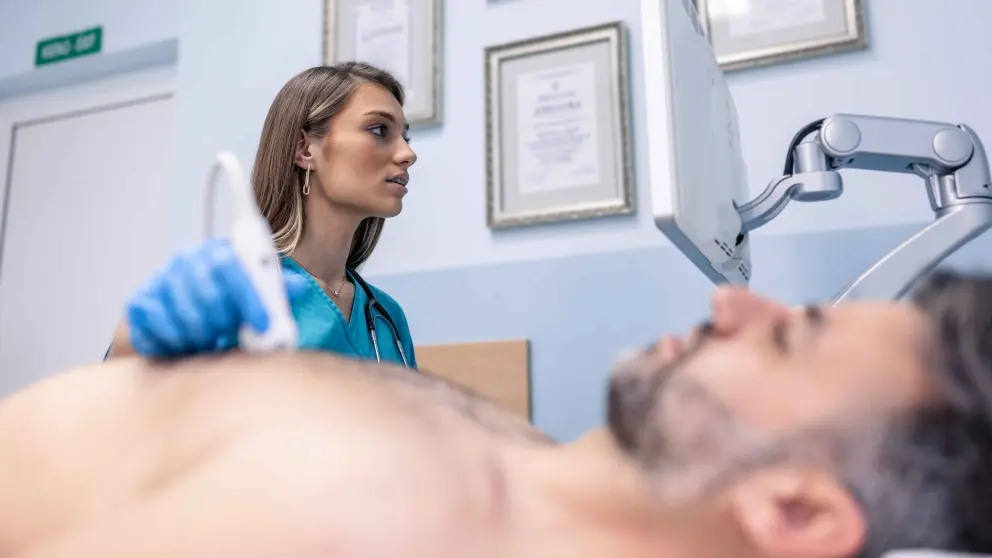 Ärztin untersucht Herz eines Patienten mit Ultraschall