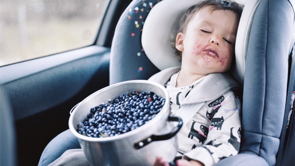 Kleinkind sitzt schlafen im Autositz mit schmutzigem Mund