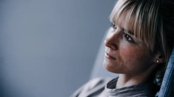 Junge Frau blickt traurig in die Ferne