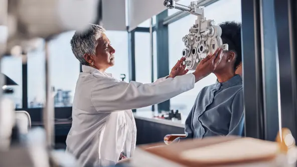 Augenärztin untersucht einen Patienten mit einem speziellen Messgerät