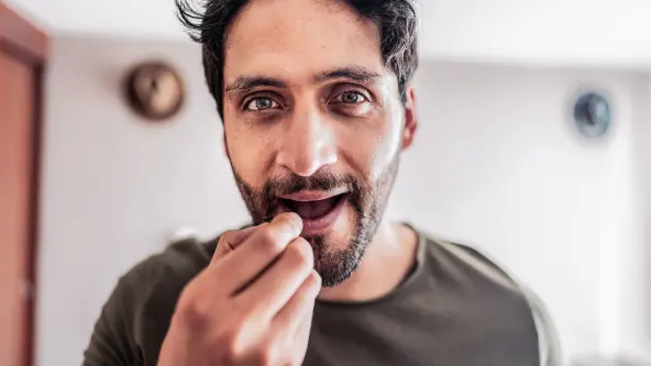 Junger Mann spürt ein Lippenblässchen an seiner Lippe