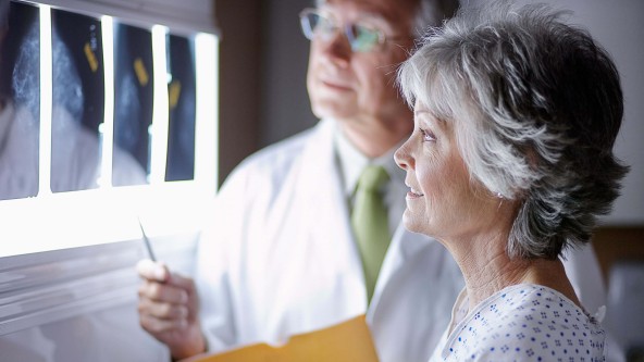 Ältere Frau schaut sich mit einem Arzt Röntgenbilder an
