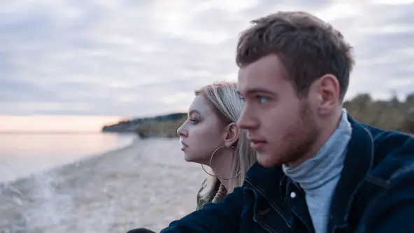 Mann und Frau sitzend rauchend am Strand