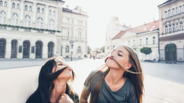 2 Teenager halten ihre langen Haare zu einem Schnurrbart ins Gesicht