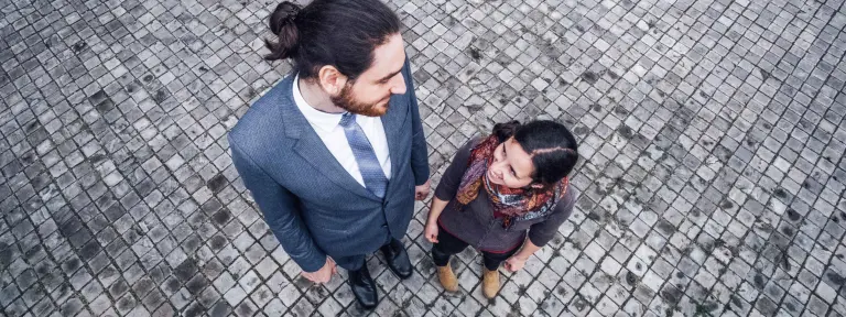 Ein großer Mann und eine kleine Frau stehen nebeneinander und schauen sich an