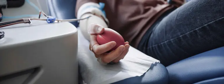 Eine Frau liegt auf einem Krankenbett und ist an ein Dialysegerät angeschlossen
