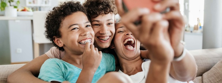 Mutter macht mit ihren 2 Söhnen ein Selfie mit dem Smartphone
