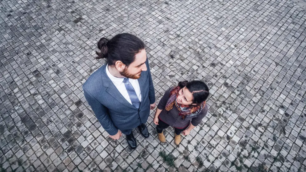 Ein großer Mann und eine kleine Frau stehen nebeneinander und schauen sich an