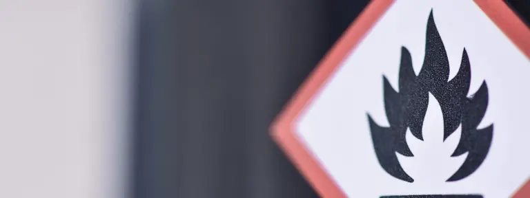 Großes viereckiges Schild mit rotem Rahmen und einem in schwarz dargestellten Feuer in der Mitte