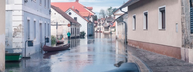 Überschwemmte Straße zwischen zwei Häuserfronten