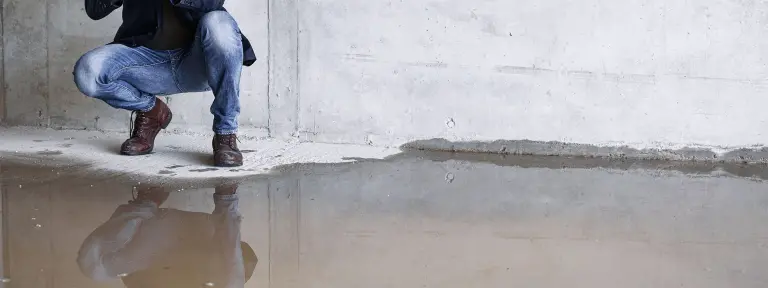 Mann begutachtet mit einer Kamera das Wasser in einem Wohnraum