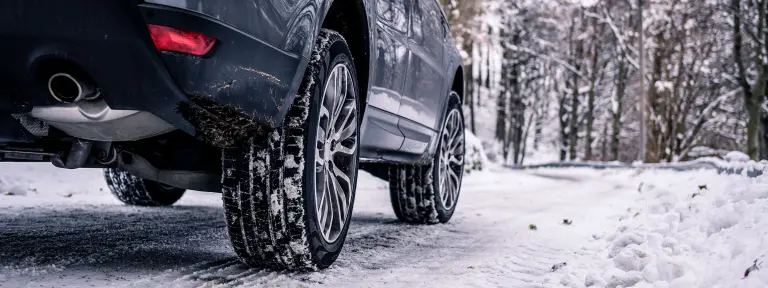 Ein Auto fährt auf schneebedeckter Straße