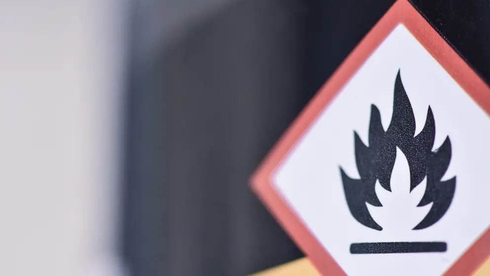Großes viereckiges Schild mit rotem Rahmen und einem in schwarz dargestellten Feuer in der Mitte