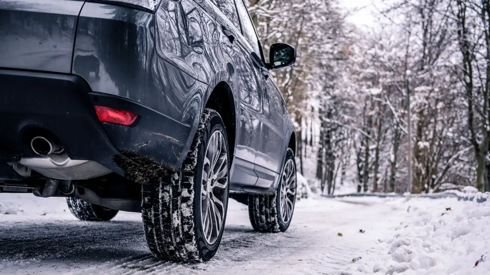 Ein Auto fährt auf schneebedeckter Straße
