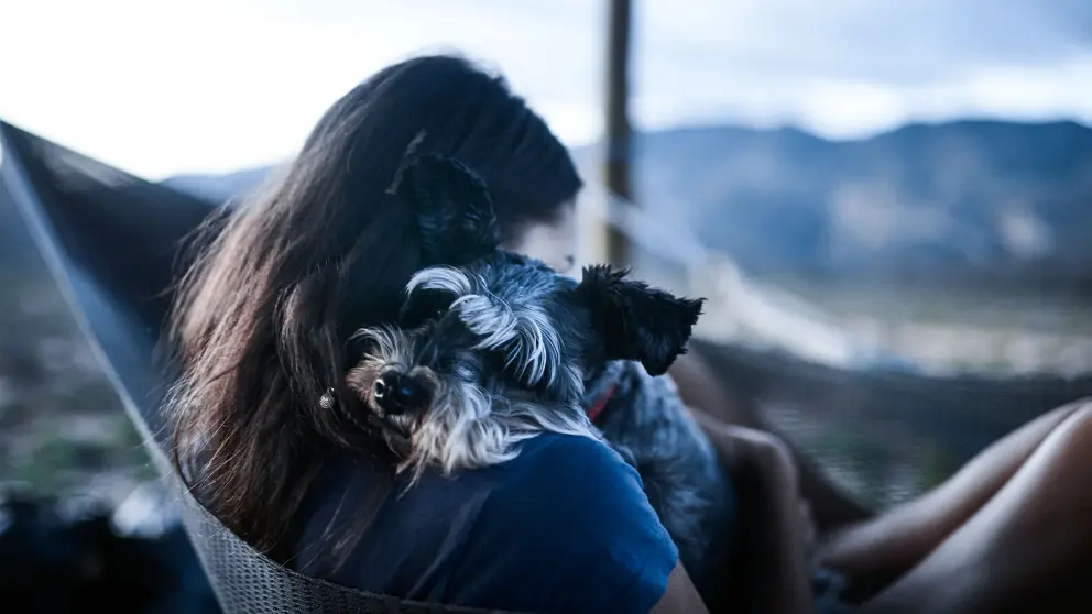 Frau kuschelt mit Hund